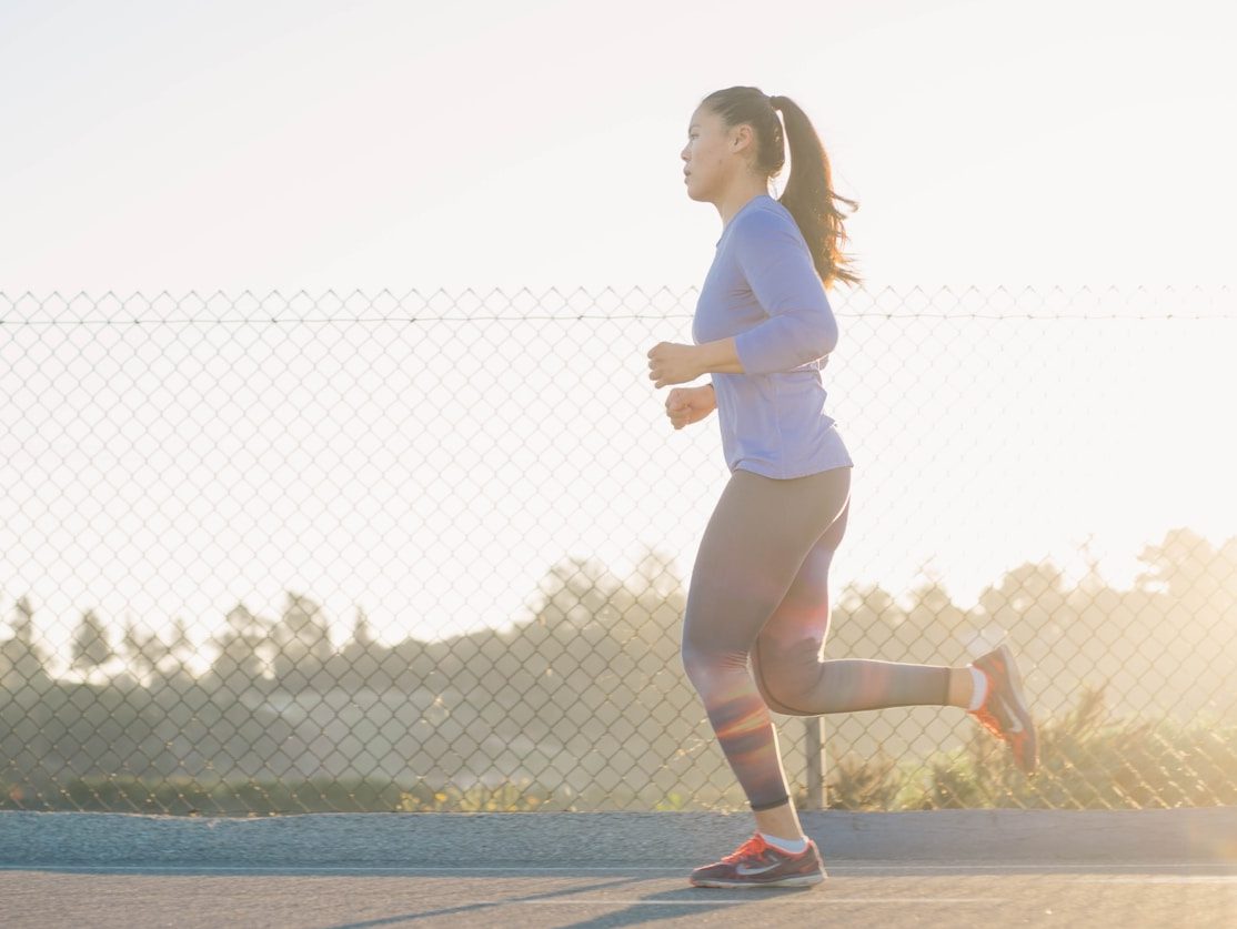 woman jogging near wire fence